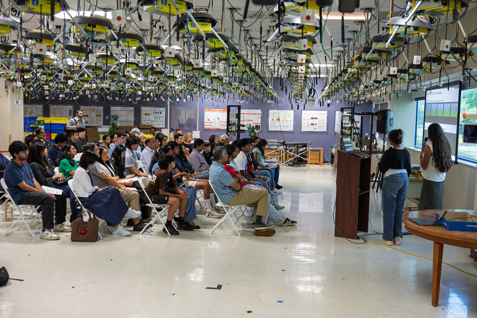 Interns present research to a seated audience in the WINLAB ORBIT grid room during the 2026 Summer Internship Open House